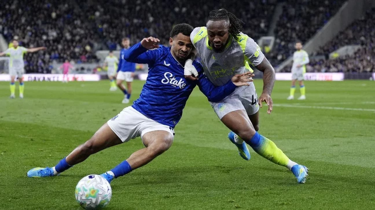 Two players battling for the ball on the pitch Two players battling for the ball on the pitch