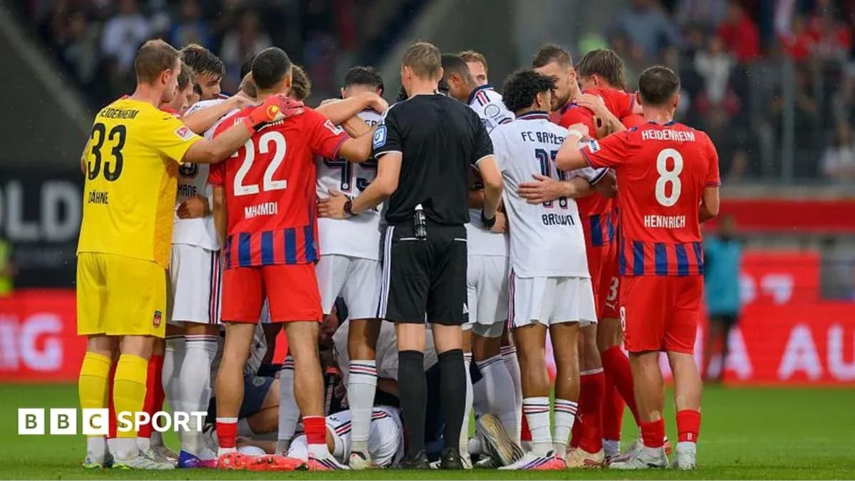 Players from both teams huddled together on field Players from both teams huddled together on field