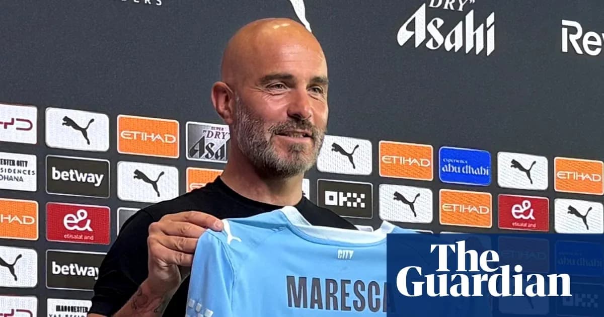 Coach holding Maresca jersey at press conference Coach holding Maresca jersey at press conference