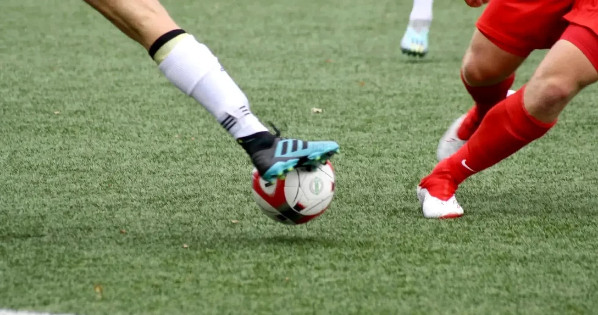Players competing for the ball in football match Players competing for the ball in football match