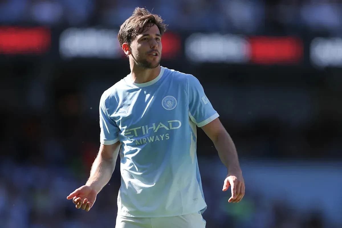 Player in light blue Manchester City kit on field Player in light blue Manchester City kit on field