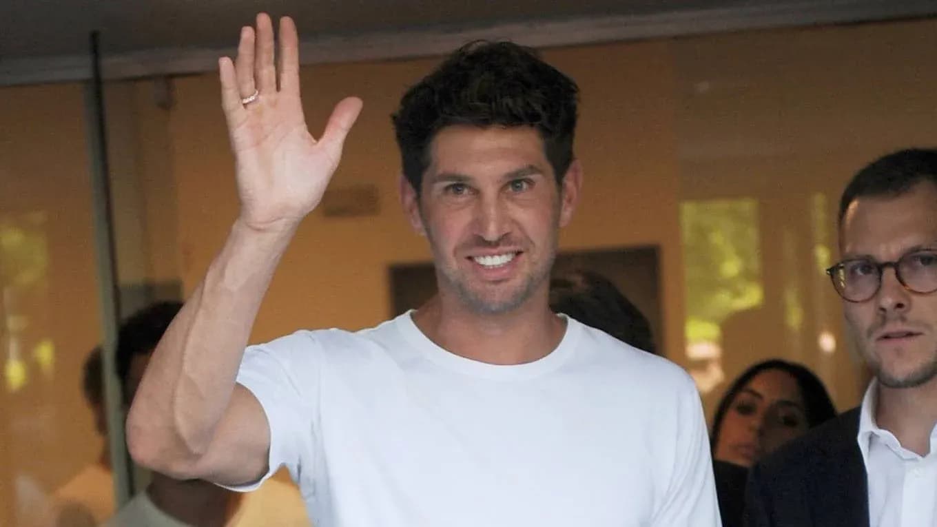 Man waving while standing with others in background Man waving while standing with others in background