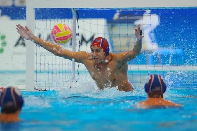 Goalkeeper attempting to block water polo shot Goalkeeper attempting to block water polo shot