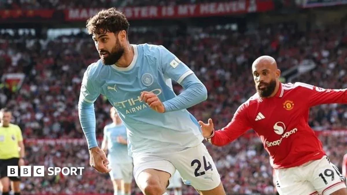 Manchester City player evading Manchester United opponent Manchester City player evading Manchester United opponent