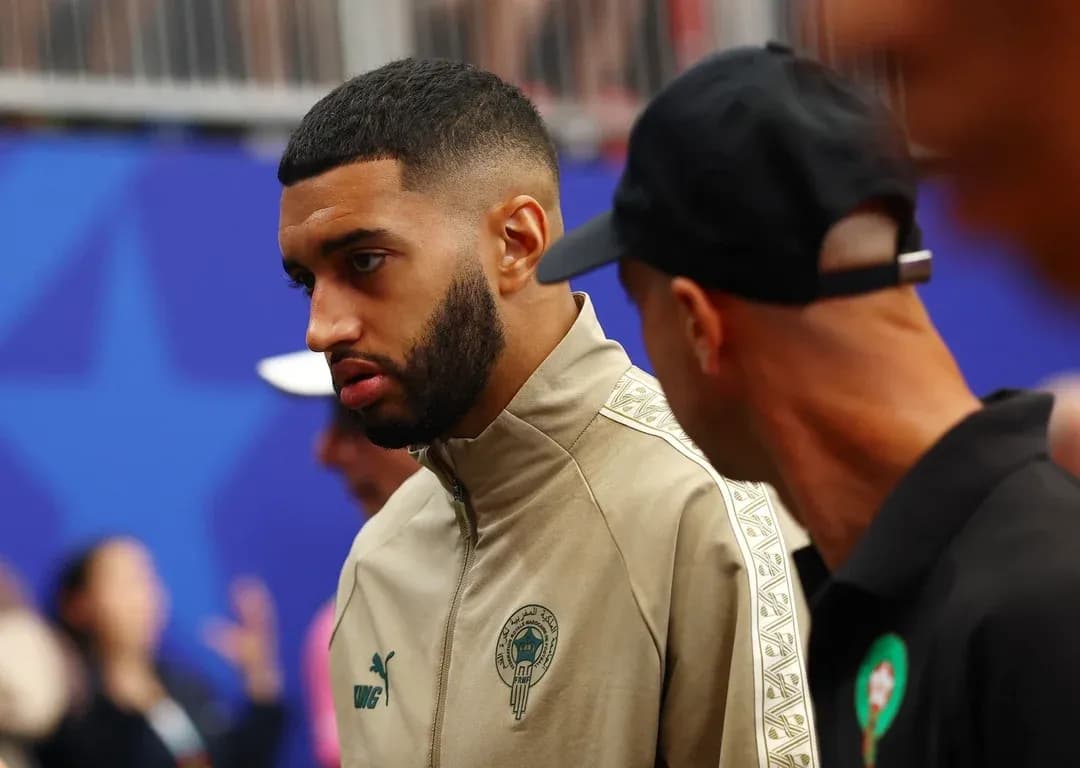 Player in team tracksuit talking with another person Player in team tracksuit talking with another person