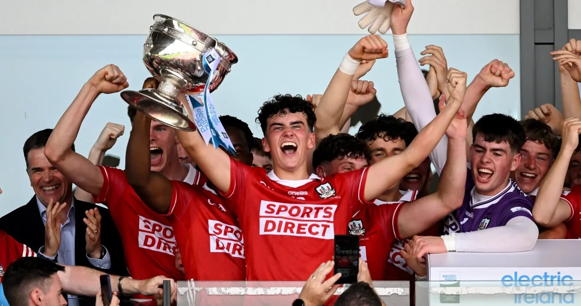Team celebrating victory with trophy in hands Team celebrating victory with trophy in hands