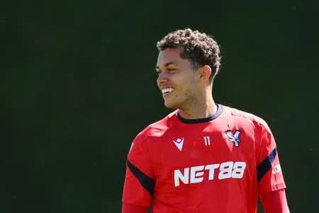 Player in red training kit smiling during practice Player in red training kit smiling during practice