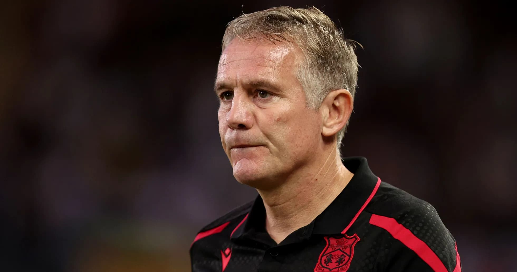Coach in black shirt with red accents during match Coach in black shirt with red accents during match