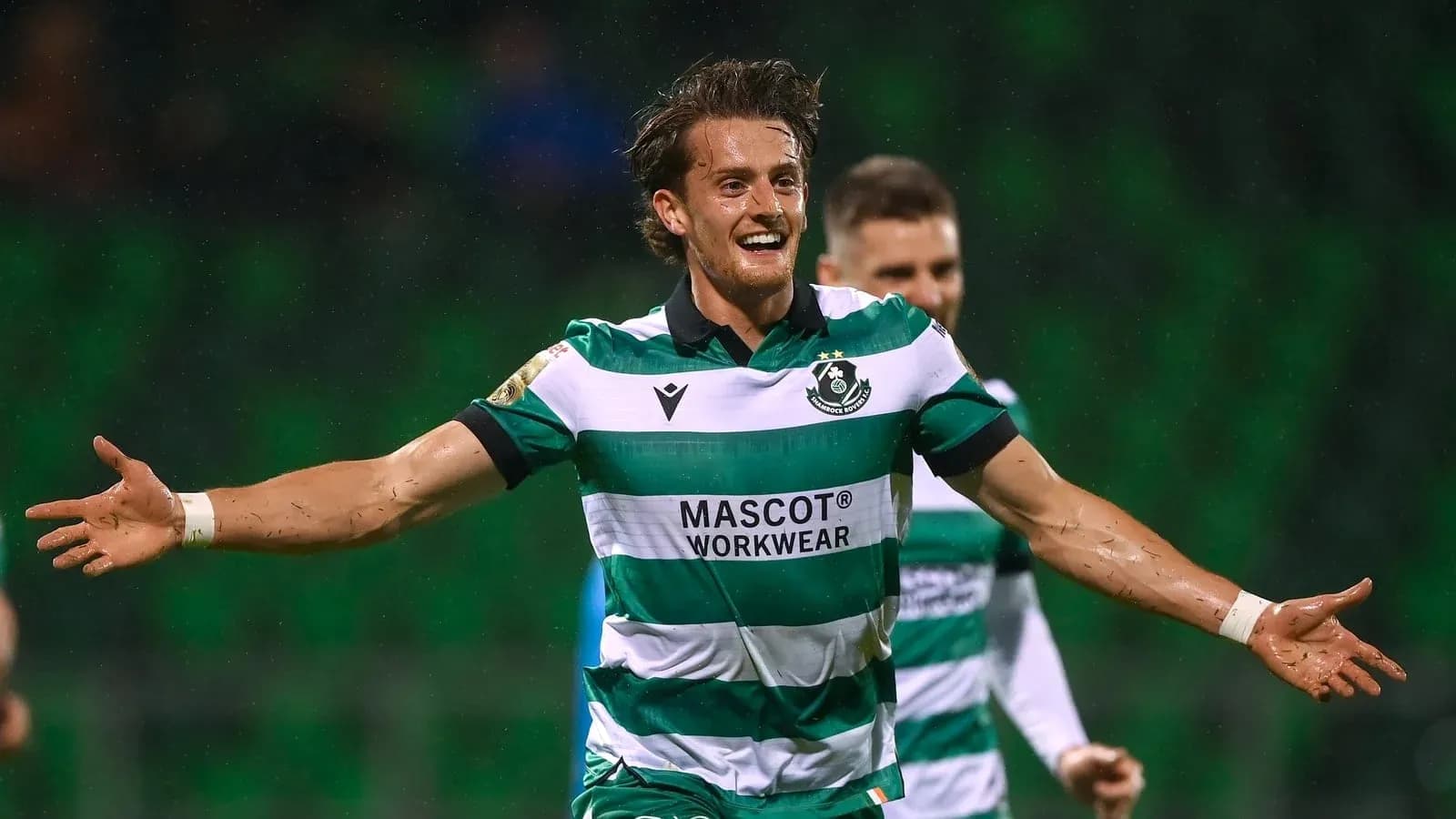 Player celebrating a goal in green and white kit Player celebrating a goal in green and white kit