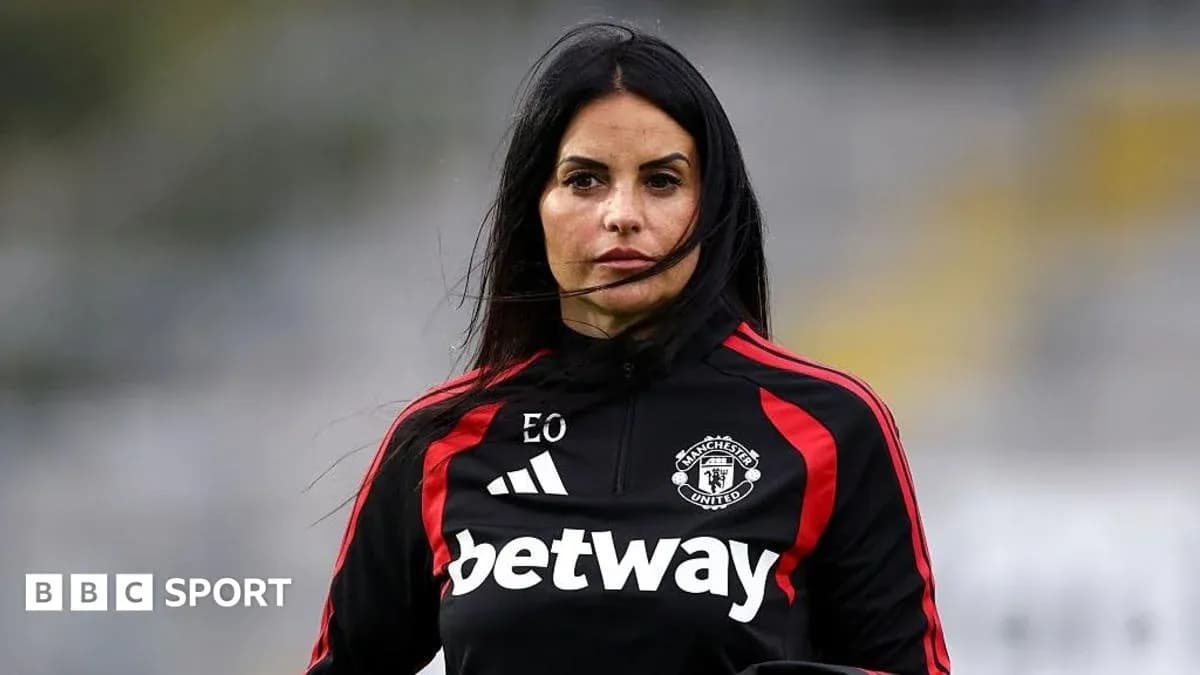 Coach in Manchester United training attire on pitch Coach in Manchester United training attire on pitch