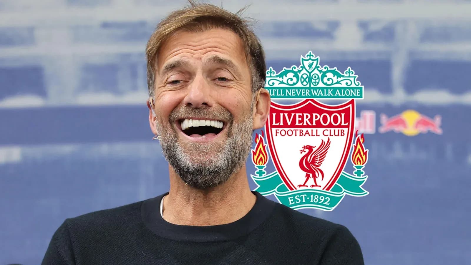 Manager smiling during press conference with Liverpool logo Manager smiling during press conference with Liverpool logo