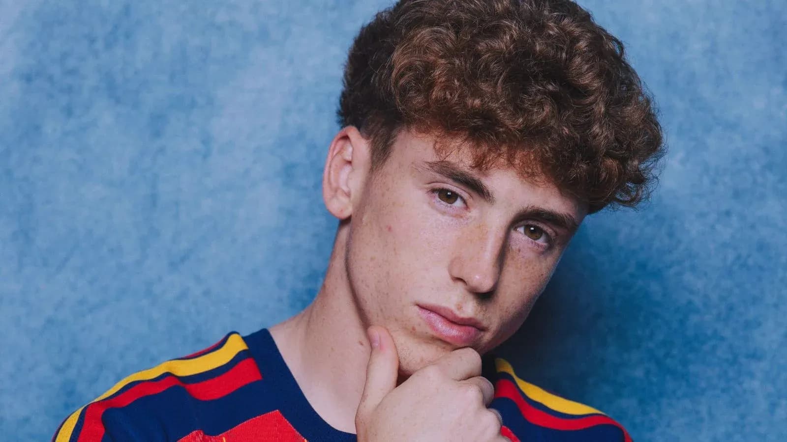 Young man with curly hair posing thoughtfully Young man with curly hair posing thoughtfully