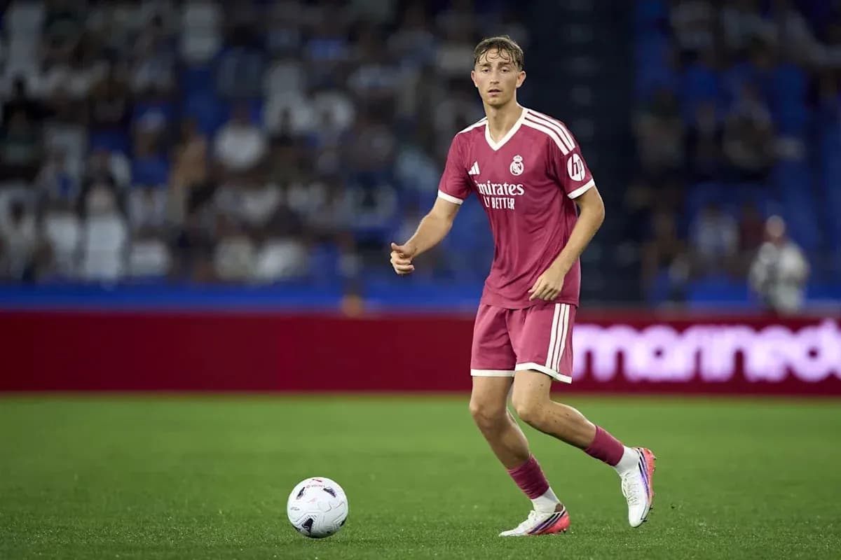 Player in pink kit dribbling the ball on field Player in pink kit dribbling the ball on field