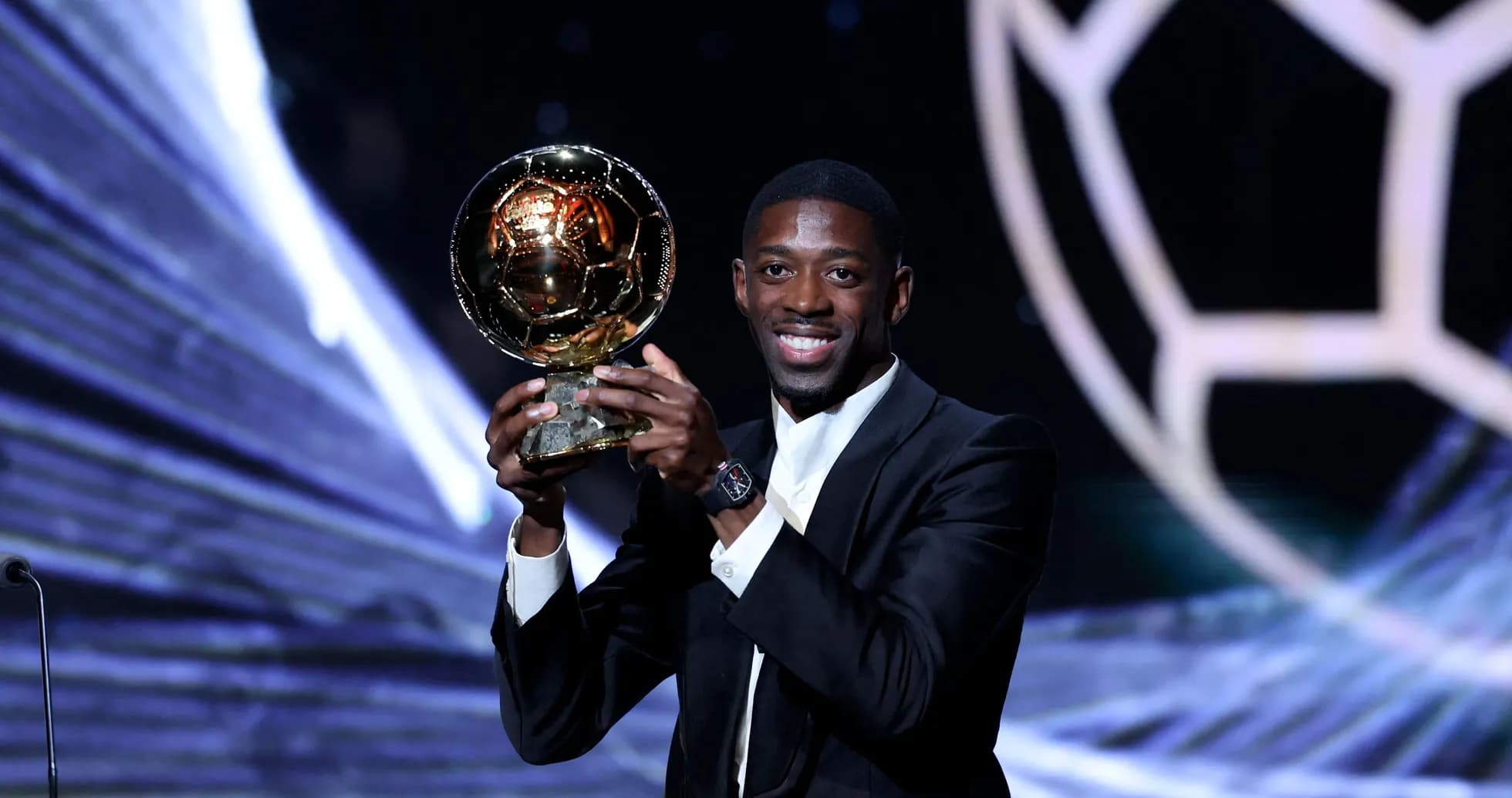 Player holding the Ballon d'Or trophy on stage Player holding the Ballon d'Or trophy on stage