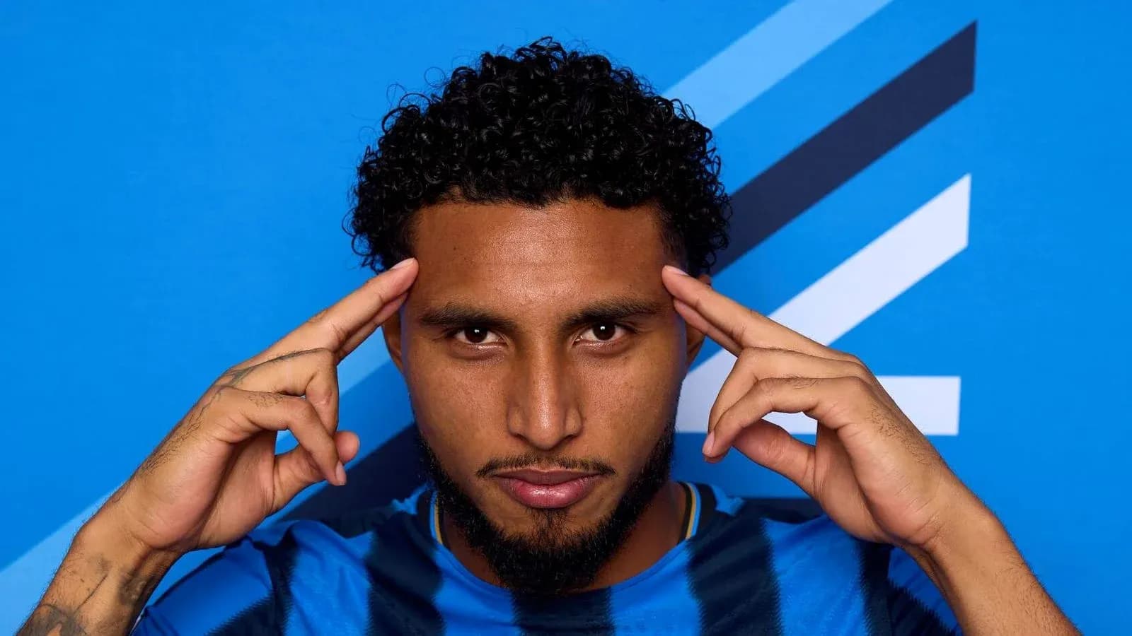 Player posing with hands on head against blue background Player posing with hands on head against blue background
