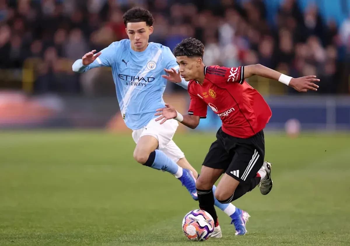 Manchester United player dribbling past Manchester City opponent Manchester United player dribbling past Manchester City opponent
