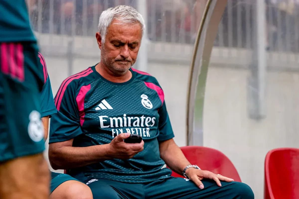 Manager seated on bench, using phone during match Manager seated on bench, using phone during match