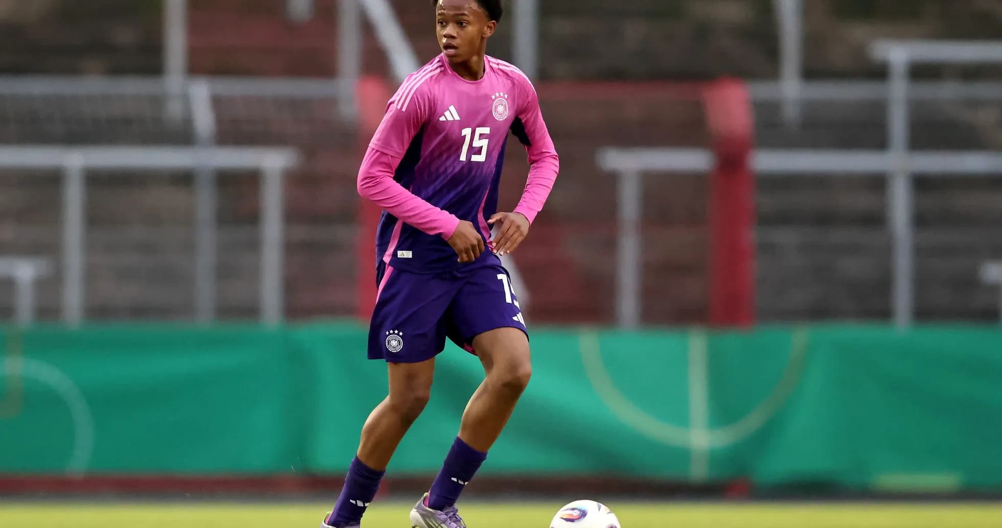 Player in pink and purple kit during training session Player in pink and purple kit during training session
