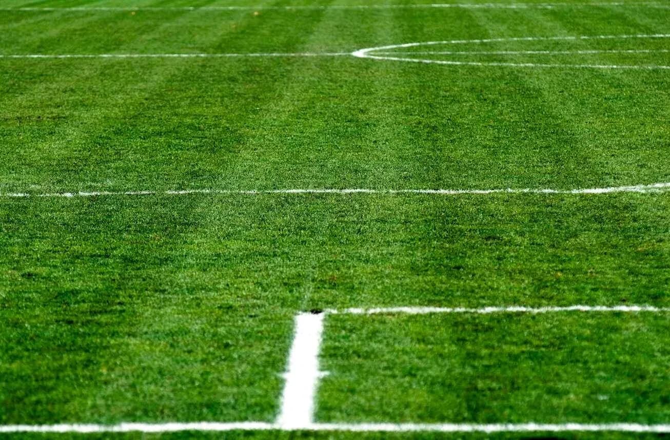 Green soccer field with white markings Green soccer field with white markings
