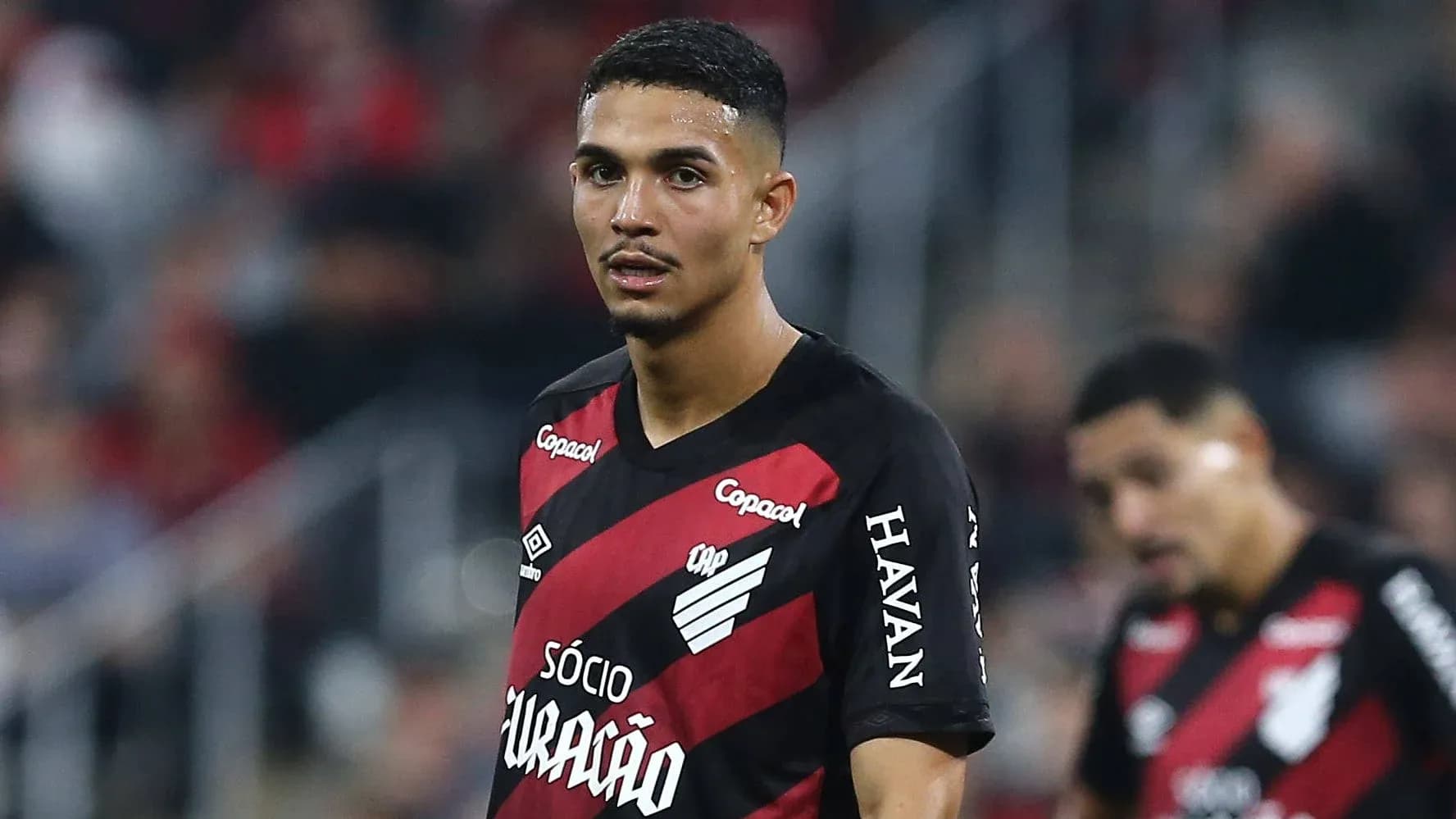 Player in red and black jersey on field Player in red and black jersey on field