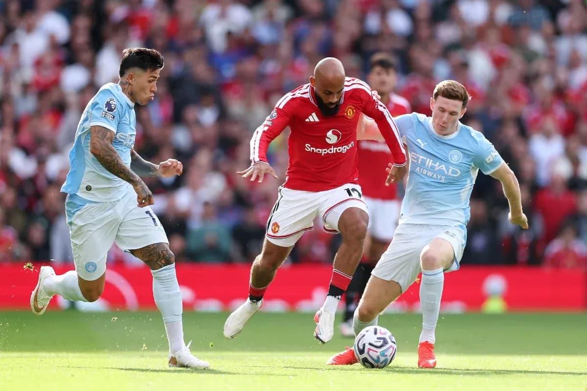 Manchester United player challenged by Manchester City opponents Manchester United player challenged by Manchester City opponents