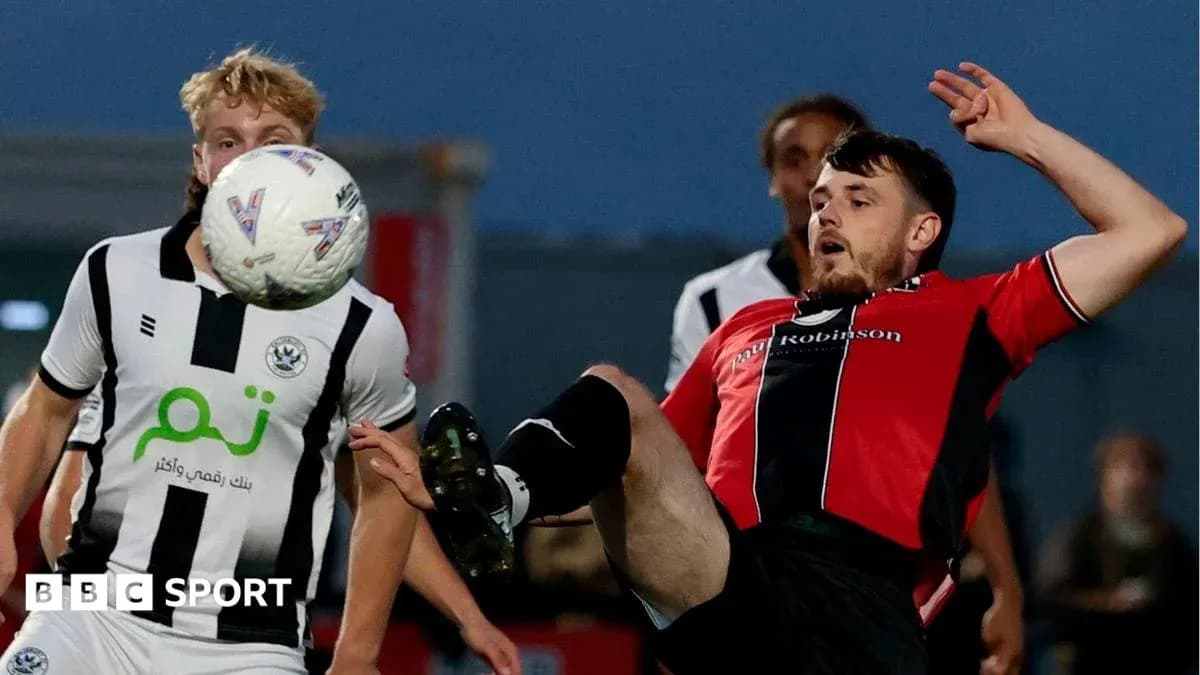 Player kicking ball while falling during match Player kicking ball while falling during match