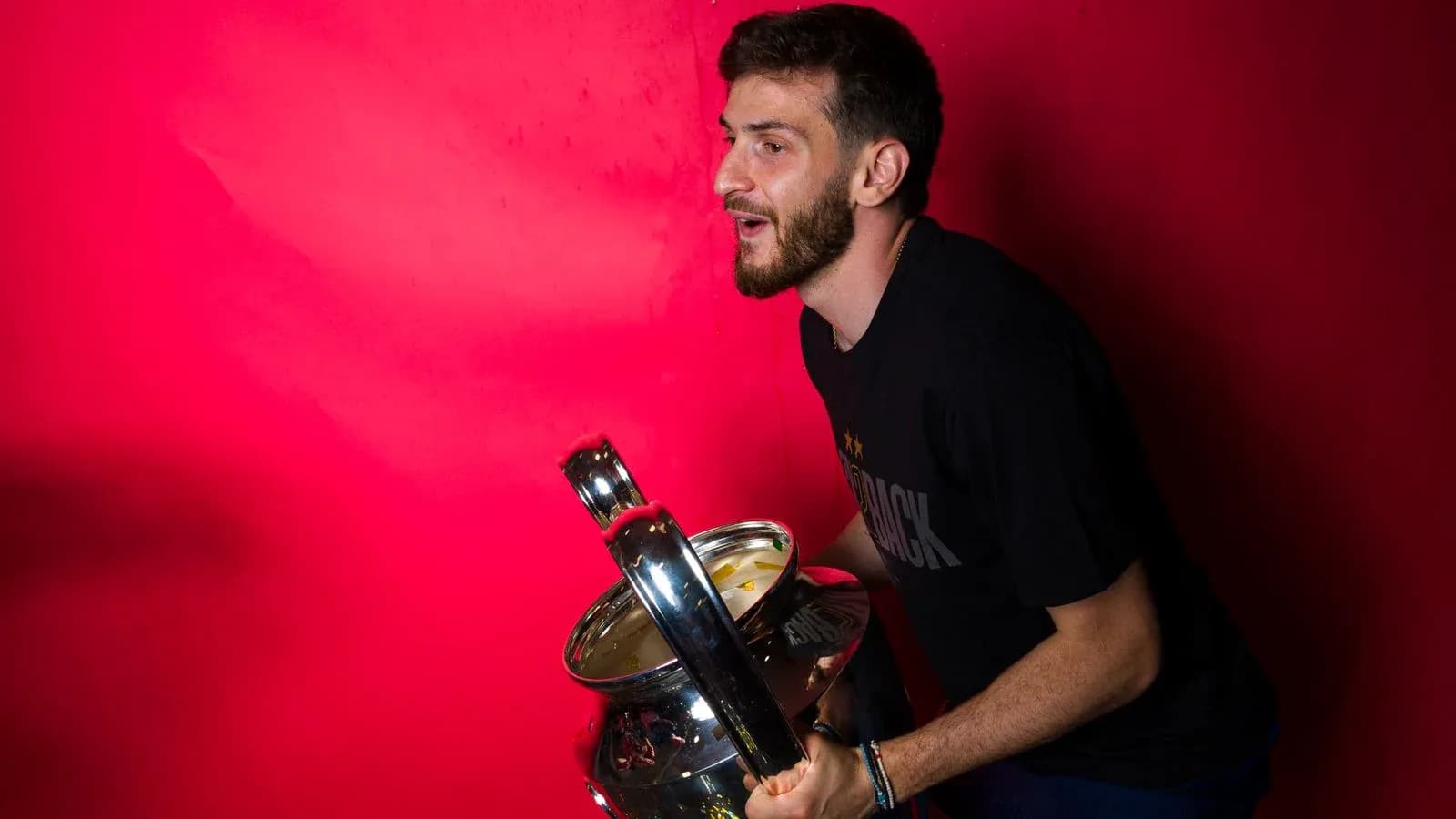 Player holding a trophy against red background Player holding a trophy against red background