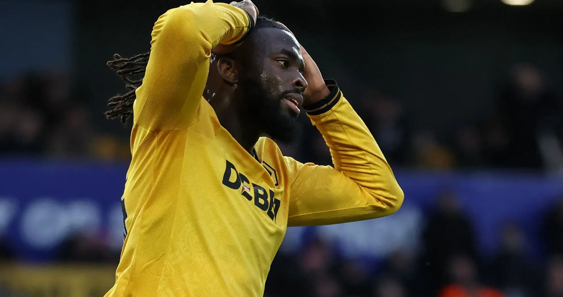 Player in yellow jersey holding head in disappointment Player in yellow jersey holding head in disappointment