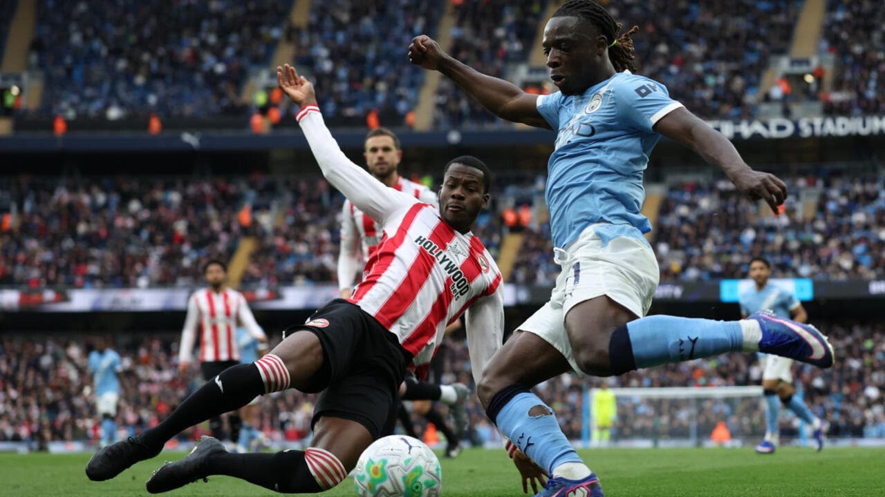 Player tackling opponent during match at Etihad Stadium Player tackling opponent during match at Etihad Stadium
