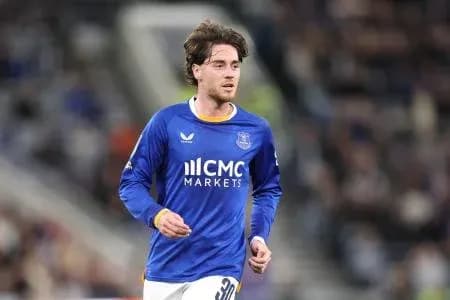 Player in blue kit running on the field Player in blue kit running on the field