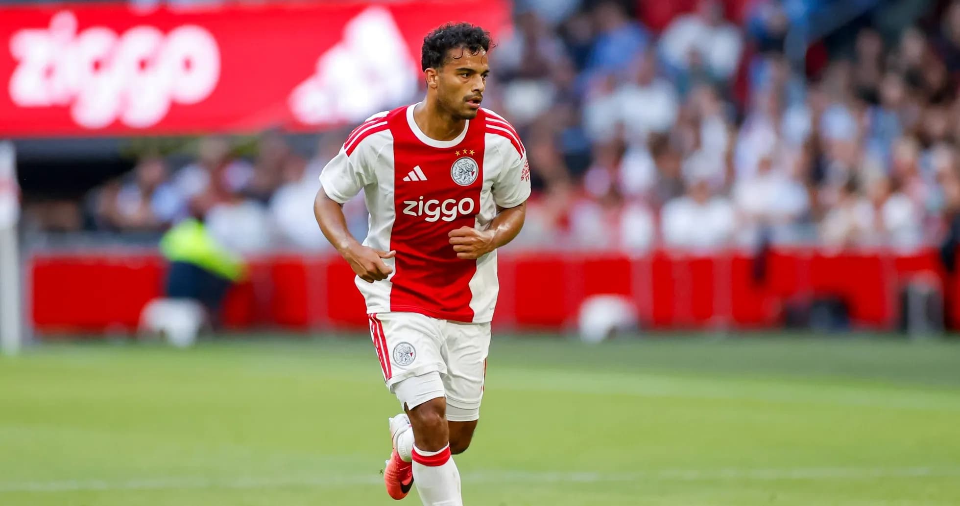 Player in Ajax kit running with the ball Player in Ajax kit running with the ball