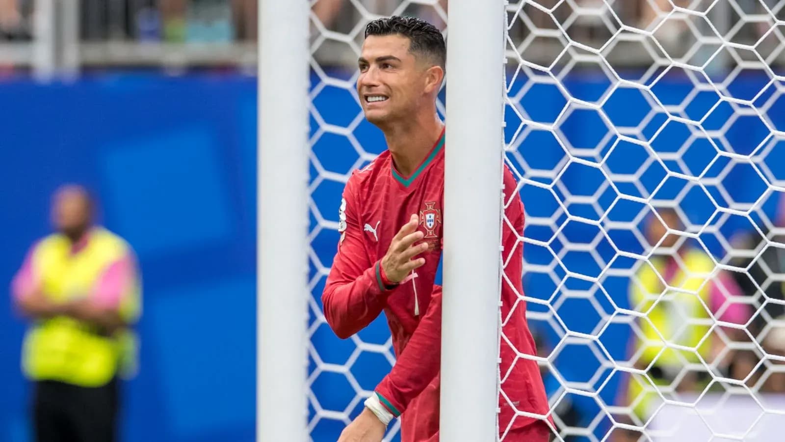 Player in red jersey near goalpost during match Player in red jersey near goalpost during match