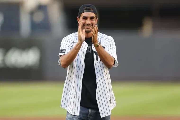 Man in Yankees jersey clapping on baseball field Man in Yankees jersey clapping on baseball field