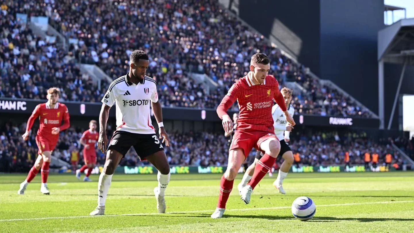Liverpool player dribbling against Fulham defender Liverpool player dribbling against Fulham defender