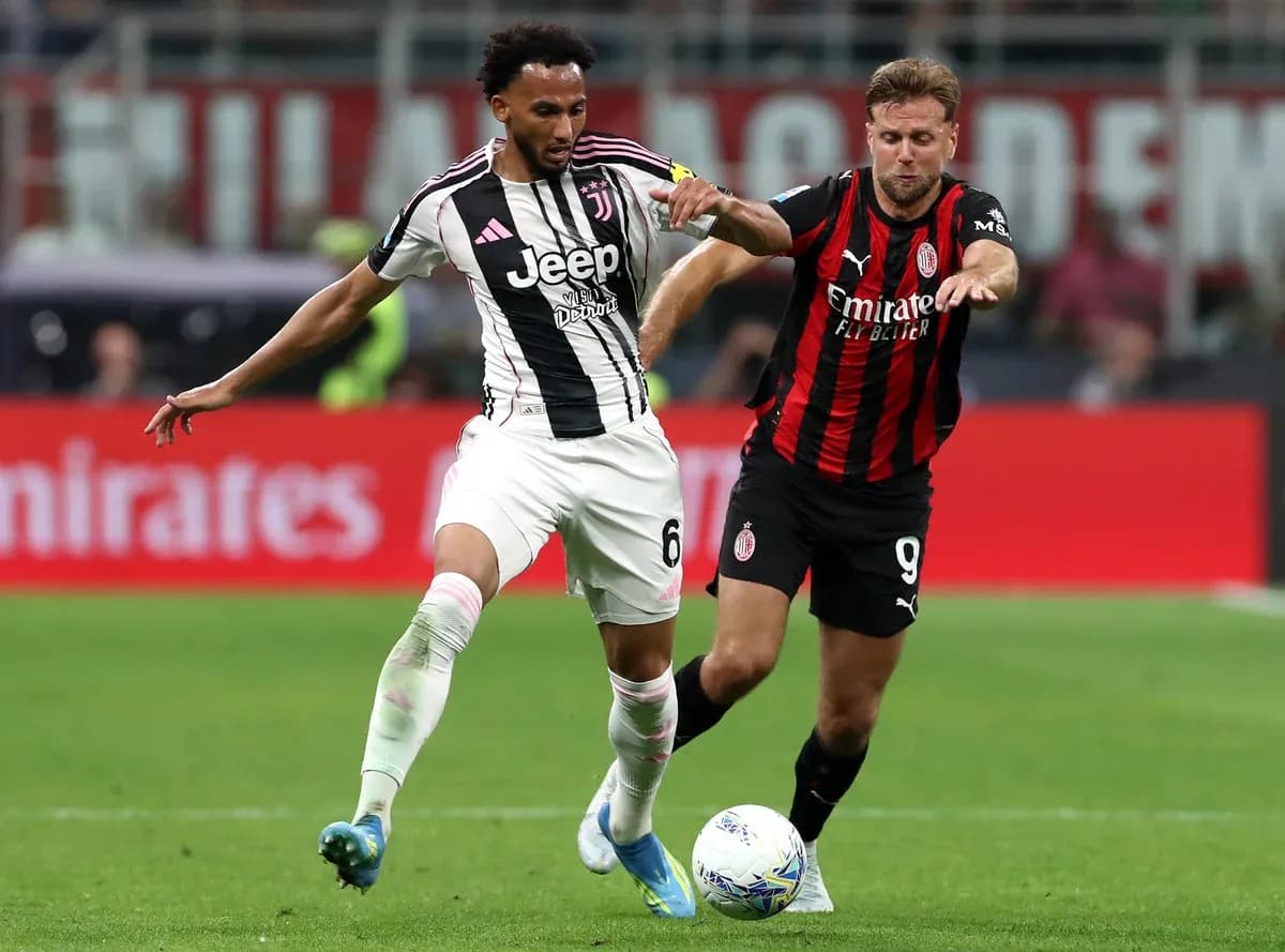 Juventus player challenges AC Milan opponent for ball Juventus player challenges AC Milan opponent for ball
