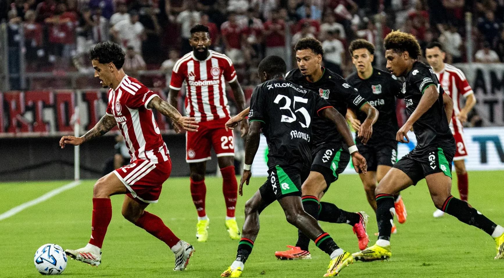 Olympiakos player dribbling against NEC Nijmegen defenders Olympiakos player dribbling against NEC Nijmegen defenders