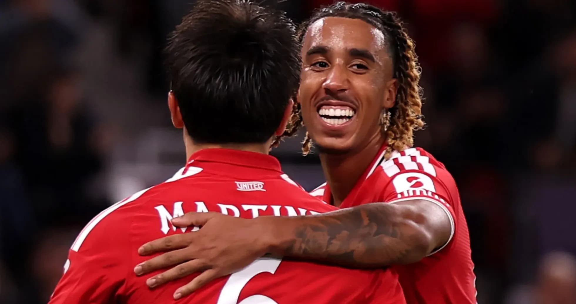 Two players celebrating together on the pitch Two players celebrating together on the pitch