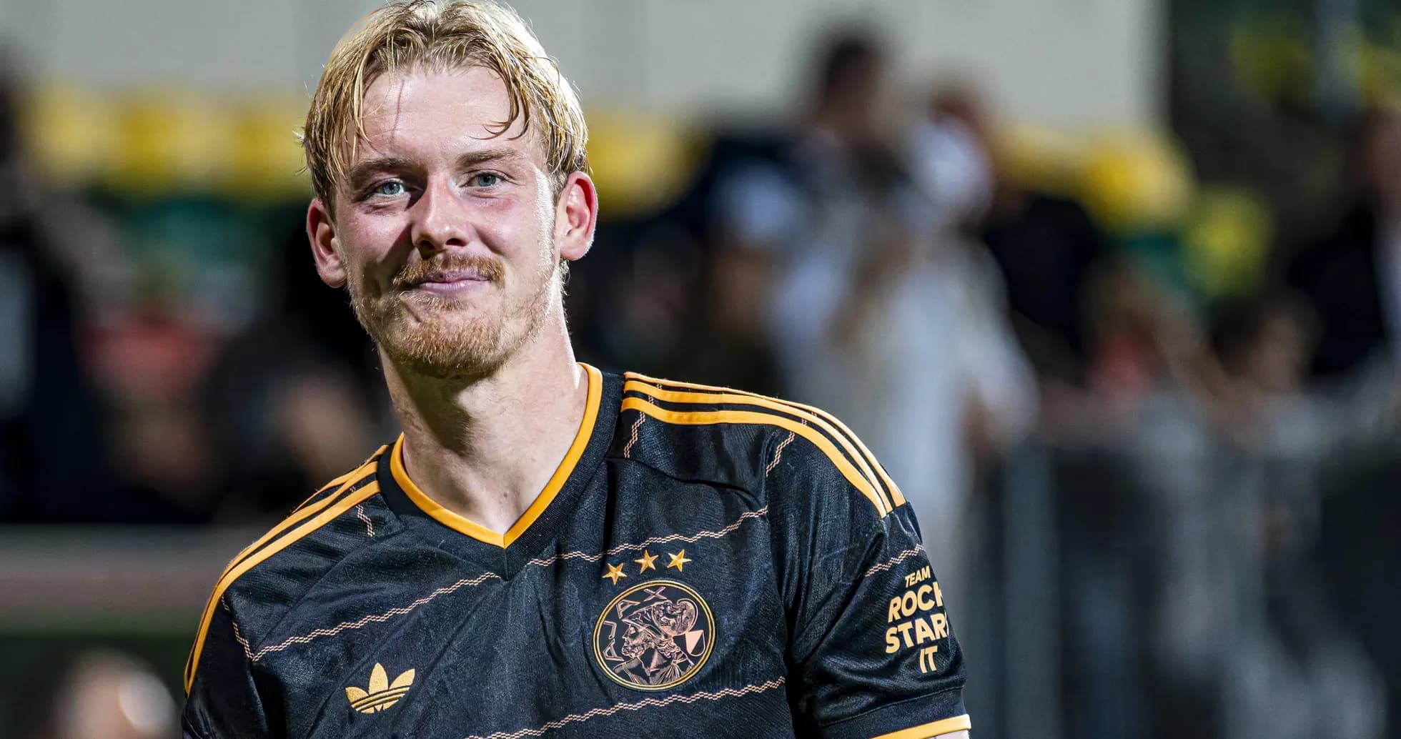 Football player smiling in Ajax jersey after match Football player smiling in Ajax jersey after match