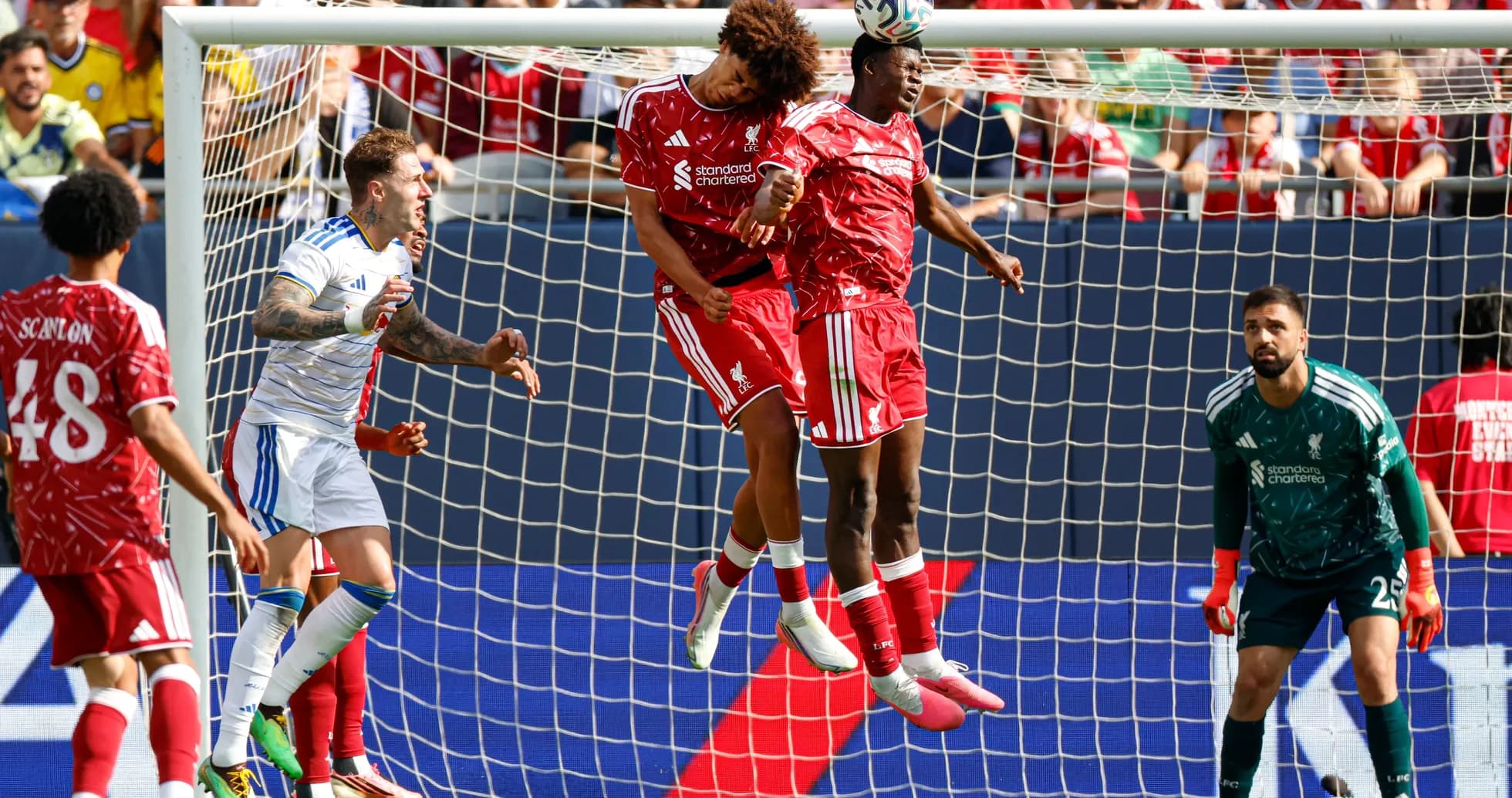 Two players jumping to head the ball in goal area Two players jumping to head the ball in goal area