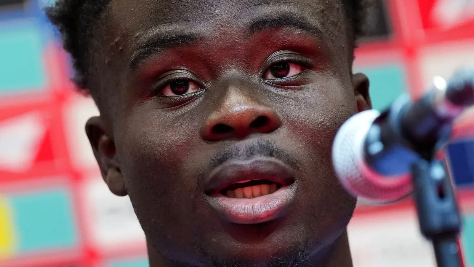 Player speaking at a press conference with microphone Player speaking at a press conference with microphone