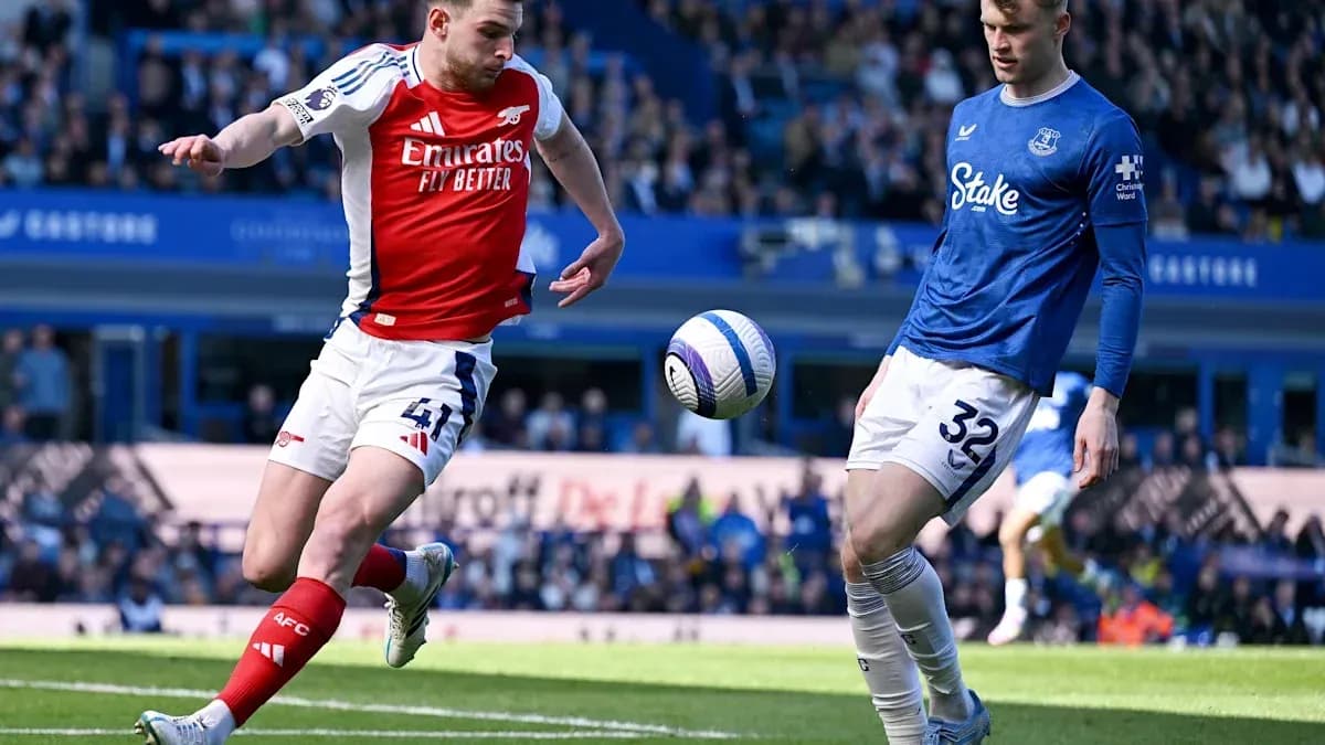 Arsenal player kicking ball near Everton defender Arsenal player kicking ball near Everton defender