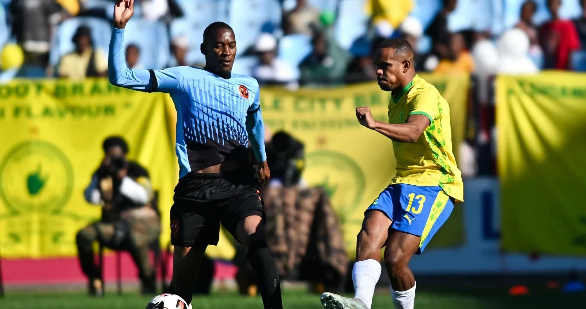 Player kicking ball while opponent defends during match Player kicking ball while opponent defends during match