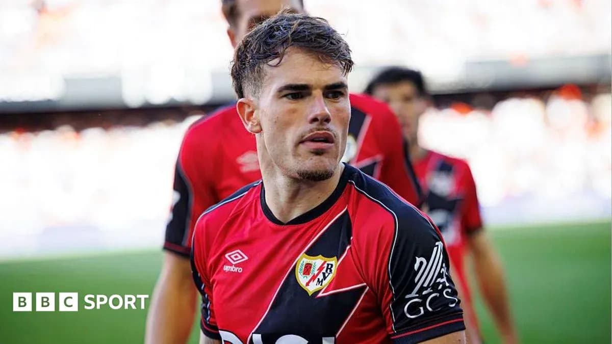 Player in red and black jersey on the field Player in red and black jersey on the field