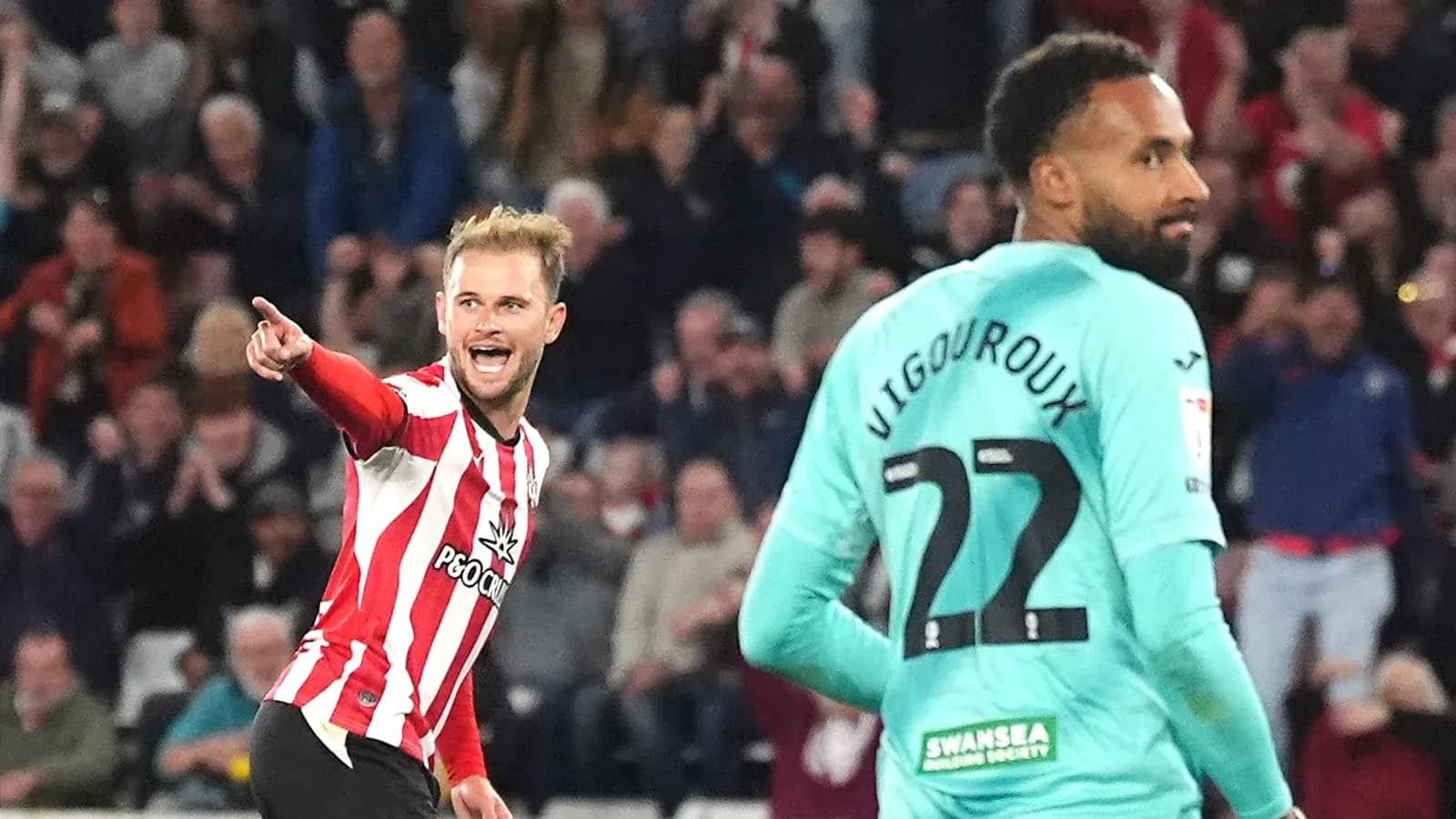 Player celebrating a goal against opposing goalkeeper Player celebrating a goal against opposing goalkeeper