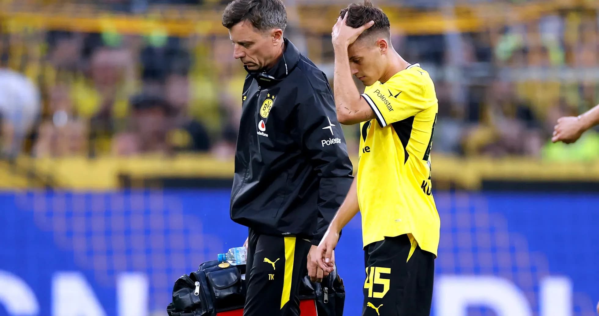 Player receiving assistance from staff after injury Player receiving assistance from staff after injury