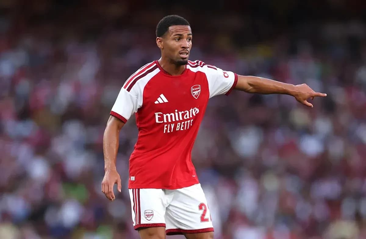 Player in Arsenal kit directing teammates on field Player in Arsenal kit directing teammates on field