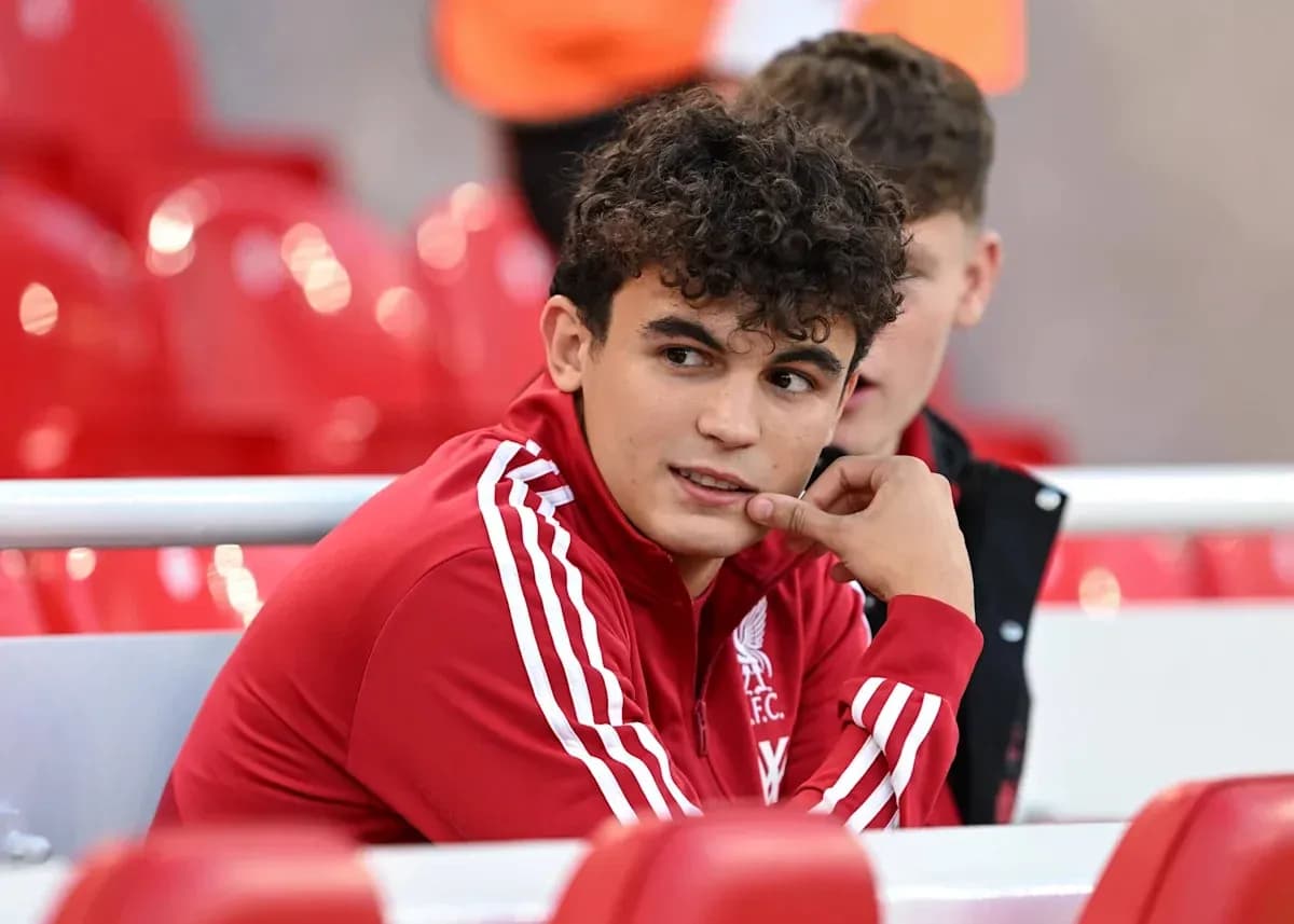 Player in Liverpool FC tracksuit sitting on bench Player in Liverpool FC tracksuit sitting on bench