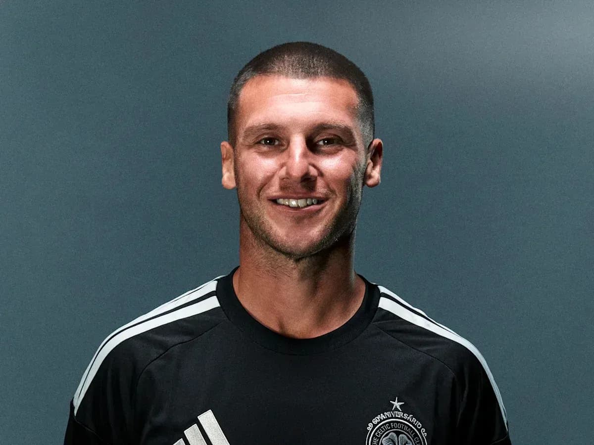 Player posing in black jersey with club logo Player posing in black jersey with club logo
