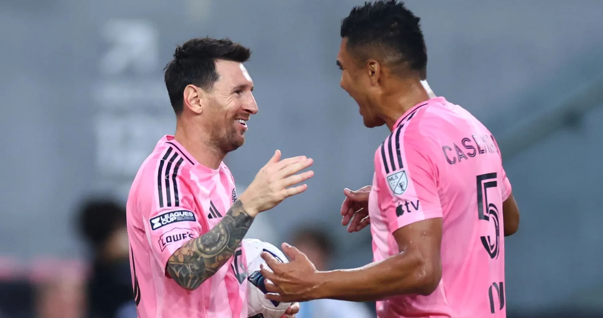 Players celebrating a goal in pink jerseys Players celebrating a goal in pink jerseys