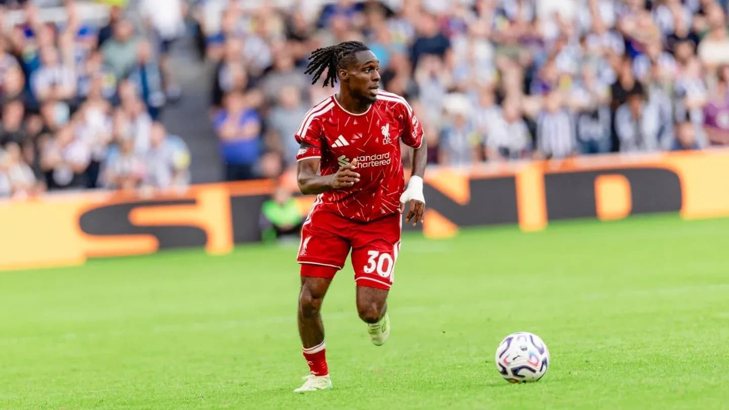 Player in red kit running with ball during match Player in red kit running with ball during match